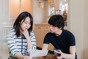 Fototapeta premium 請求書明細を見て値上げに苦しむ若い夫婦
