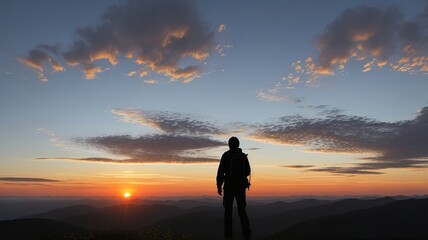 Silhouette of a Hiker Standing on a Mountain Peak at Sunrise
