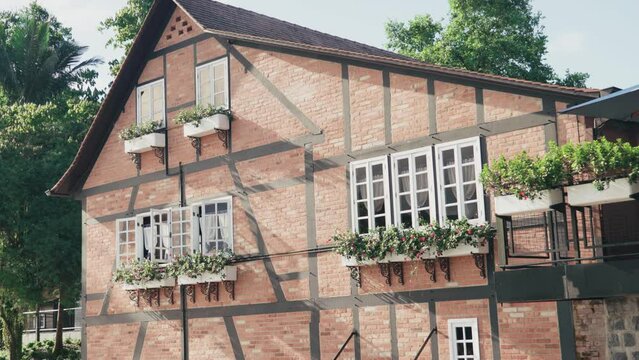 German traditional architecture half-timbered houses. Flower pots on the windows. 
