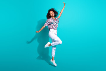Full length photo of cheerful optimistic good mood girl wear trendy clothes fly air have fun weekend isolated on cyan color background © deagreez