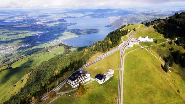 a spectacular panoramic view of Zugersee Lake from the high-altitude funicular station on Mount Rigi, featuring the iconic Rigi Staffel Cogwheel Train Station in Switzerland 