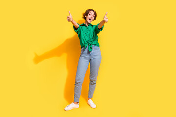 Full length photo of cool confident girl dressed green shirt smiling showing you thumbs up isolated...