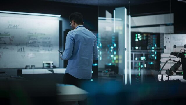 Slow Motion Portrait of a Male Specialist Working in a Technological Startup Taking Notes from the White Board in Office. Professional Data Analyst Collecting Information for Project Development