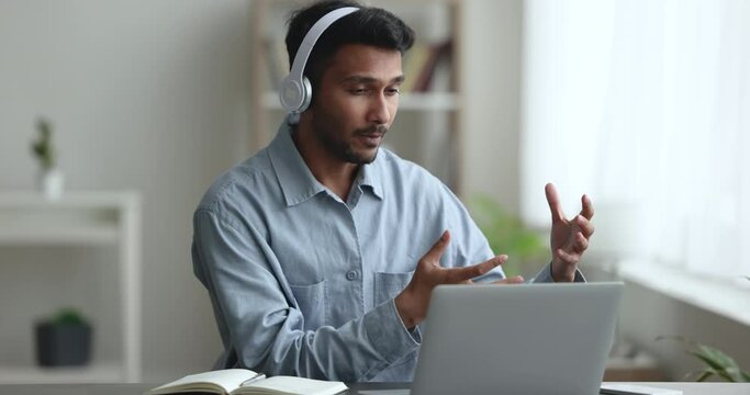 Serious Freelance Project Manager Man Talking To Business Partner On Video Call, Using Wireless Headphones And Laptop For Job Communication, Online Conference Connection, Working From Home