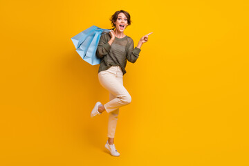 Fototapeta na wymiar Photo of lovely glad girl wear trendy outfit presenting empty space cool offer novelty empty space isolated on yellow color background