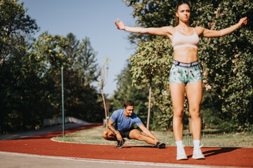 Obraz premium Caucasian couple workout outdoors in park, stretching and warming up. Sportsmanship and motivation lead to positive results for fit body, healthy lifestyle.