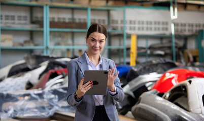 Small business owner. Caucasian business woman holding digital tablet computer standing at Car maintenance and auto service garage. Car maintenance and auto service garage concept.