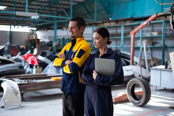 Unity and teamwork apprentice. Caucasian Female trainee Mechanics Working Underneath Car with male Instructor at Car maintenance and auto service garage
