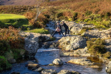 Family, mother, father and daughter having fun at mountain Dargle River. Hiking in Powerscourt,...