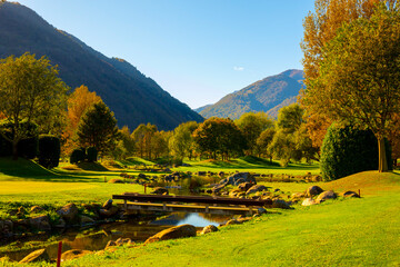 Golf Course with a River and Mountain in a Sunny Autumn Day in Losone, Switzerland.