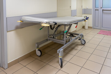 Empty medical mobile bed on wheels or stretcher trolley in hospital corridor