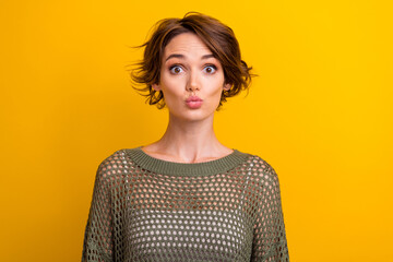 Photo of funky cute girl wear knitted khaki clothes send you kiss isolated on vibrant yellow color...