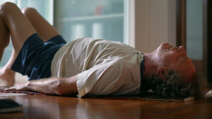 Senior man taking care of his lower back in morning exercise routine to relieve back pain. Elderly...