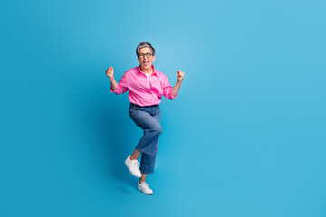 Full length photo of crazy woman with short hair dressed pink shirt raising fists dancing win lottery isolated on blue color background