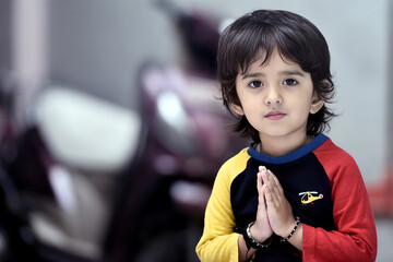 Adorable Indian baby girl giving innocent smile while greeting with her hands