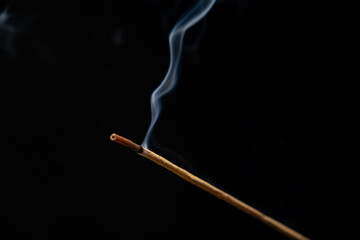 Smoke from a burning aroma stick on a black background. Incense sticks, aromatherapy and meditation.