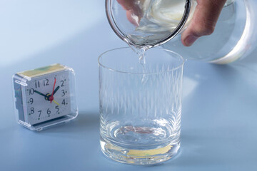 Detail of person filling glass of water. hydration concept