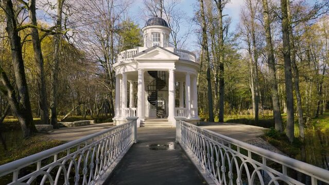 Yellow autumn in Kemeri National Park. A popular walking place in Latvia. Reflection in the pond of the restored architecture of the park. Multicolored clothes of walking tourists on a sunny day.
