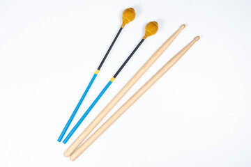 Xylophone and drum sticks on white background top view