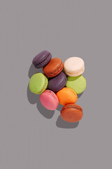 french dessert macarons, lying in a pile, different colors on a textureless gray background, top view, no people