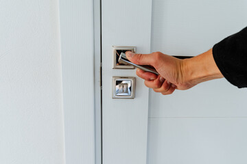 Opening the door in the room, hand opening the door by the handle, chrome door lock elements.