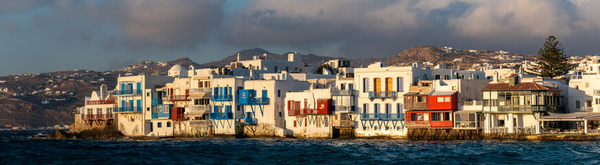 Panoramic view of Little Venice Mykonos (Chora), Cyclades Islands, Aegean Sea, Greece. Wterfront with rows of fishing houses line the waterfront with their balconies hanging over the sea. - obrazy, fototapety, plakaty