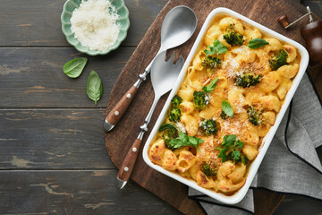 Pasta Broccoli casserole. Baked Mac and cheese with broccoli, cream sauce and parmesan on old rustic wooden background. Healthy or baby food. American Casserole Top view. Copy space. - obrazy, fototapety, plakaty