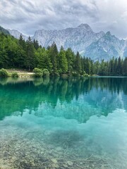 Amazing reflection of the mountain and the trees in the water of the Lago Inferiore di Fusine in the Julian Alps in the north of Italy close to Tarvisio