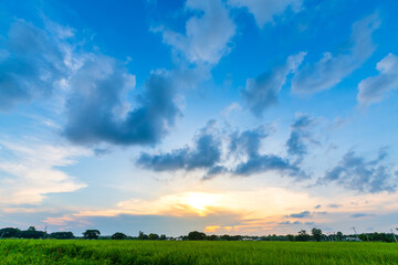 Twilight blue bright and orange yellow dramatic sunset sky in countryside or beach colorful cloudscape texture with white clouds air background.
