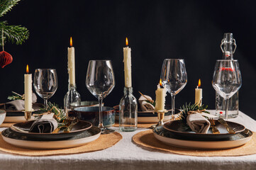 Obraz na płótnie Canvas winter holidays, dinner party and celebration concept - scandinavian christmas table serving with burning candles at home over black background