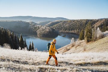 Man with backpack walking on the mountains against the background of an icy lake, mountain trekking...