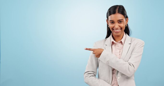 Face, business woman and pointing to presentation of space, mockup and promotion in studio on blue background. Portrait, happy indian worker and advertising announcement, news or information about us