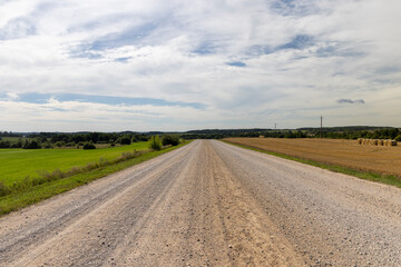 a road through a field with poor infrastructure