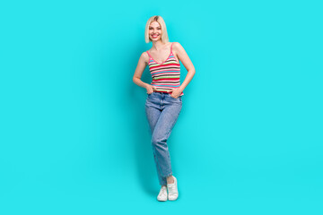 Full length photo of positive adorable lady wear striped singlet smiling walking isolated turquoise color background