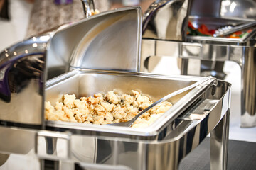 Close up of a stainless steel catering buffet in a hotel restaurant.