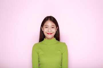 Fototapeta premium Beautiful girl smiling happily, Portrait of a beautiful young woman in a light pink background, happy and smile, posting in stand position.