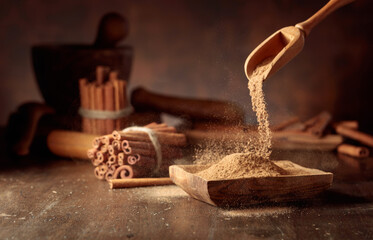 Cinnamon powder is poured into a wooden bowl.