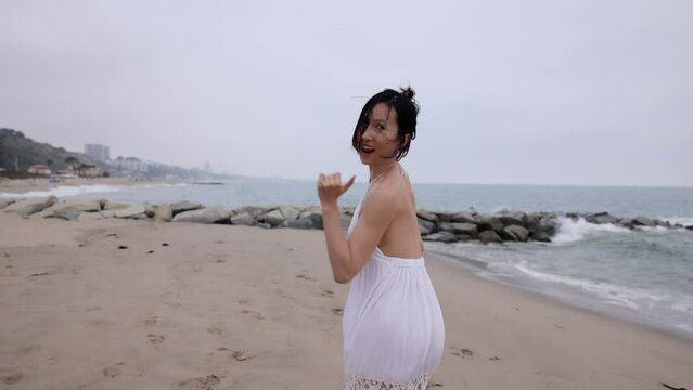 Attractive Asian woman running on the beach in Santa Monica California. Slow Motion.