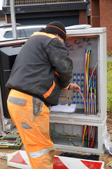 Colorful fiber optic cables for faster Internet in rural areas. An unidentifiable electrician...