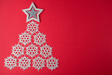 Naklejka na ściany i meble Christmas tree made of snowflakes on red background. Christmas background.