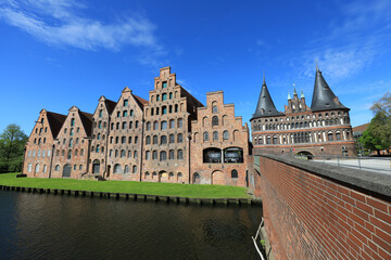 Historische Speicherhäuser am Traveufer in Lübeck unter klarem, blauem Himmel