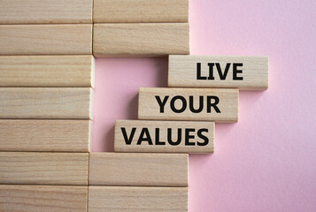 Live your values symbol. Concept words Live your values on wooden blocks. Beautiful pink background. Business and Live your values concept. Copy space.