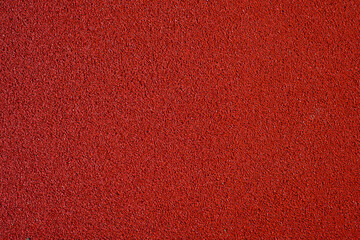 Texture of a red running track with a textured rubber surface, top view, idea for a background or...