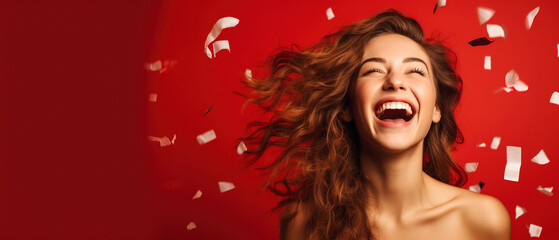 Obraz na płótnie Canvas a Young Woman laughing while bright confetti falls over, in the style of studio portraiture, bright daylight, delicate, red background