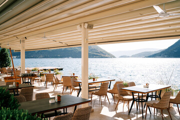 Canopy over a restaurant on a pier by the sea with a view of the mountains