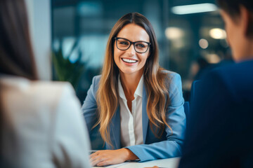 Portrait of successful female business consultant broker adviser meeting with her clients in a modern office setting - obrazy, fototapety, plakaty