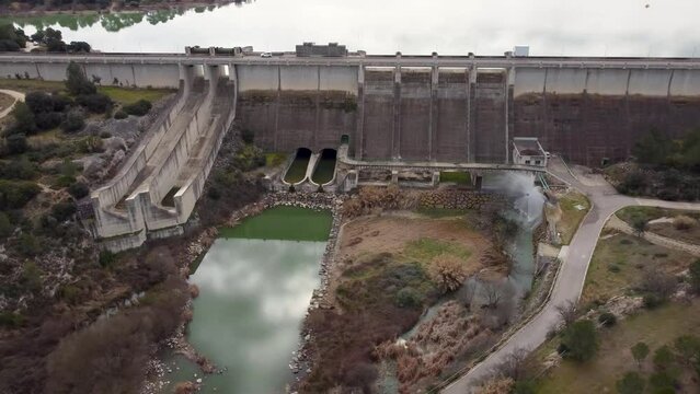 Panoramic drone video of the front of the Bell&uacute;s gravity dam for irrigation and water containment, in the province of Valencia, Spain, with a relief valve operating at full capacity