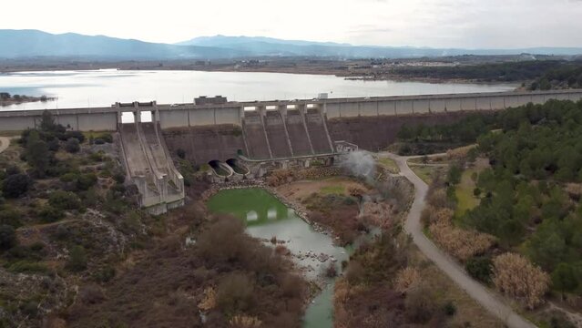 Drone video approaching the gravity dam with irrigation and water containment functions of Bell&uacute;s, in the province of Valencia, Spain, above the Albaida river