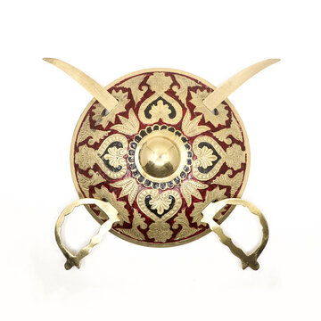 vintage sword and shield talwar weapon of warriors, handcrafted in gold with floral pattern, used by the royal guards and soldiers of the king isolated in a white background