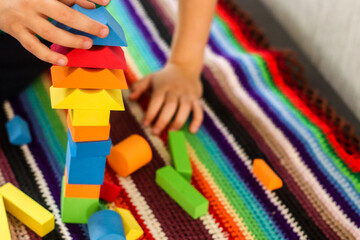 Toys colorful geometric shapes on educational games on bright mat made of fabric threads and child...